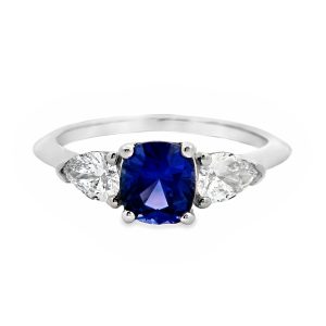 Platinum cushion shaped purple sapphire with pear shaped diamond sides.